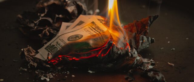 Dollar bill crumpled and on fire