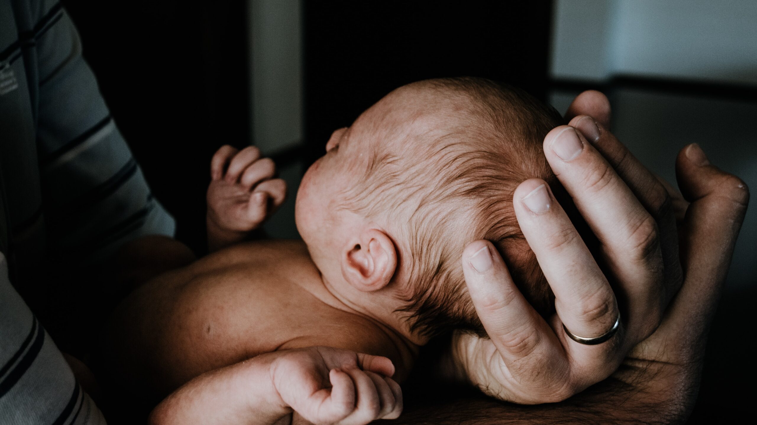 newborn baby in parents' hands