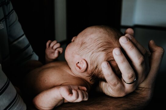 newborn baby in parents' hands