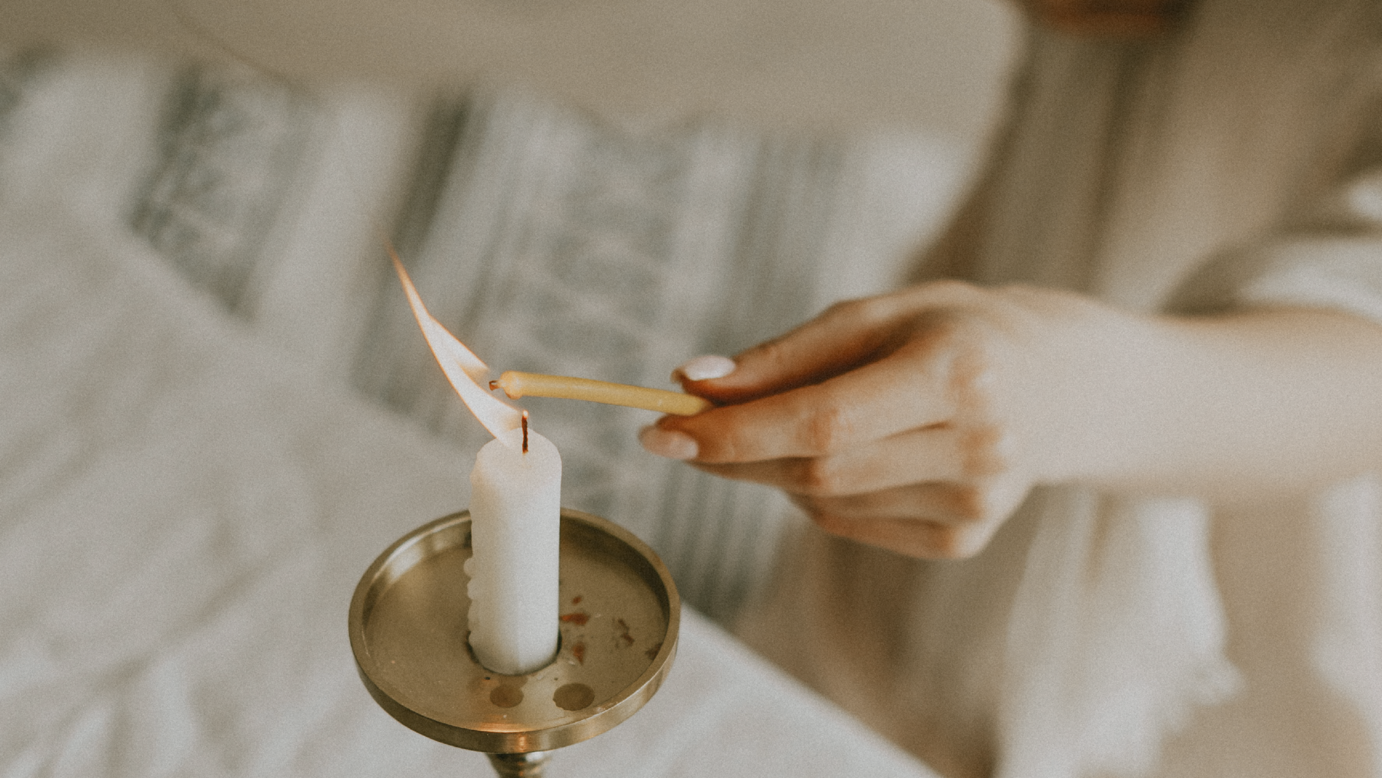 hand lighting a candle
