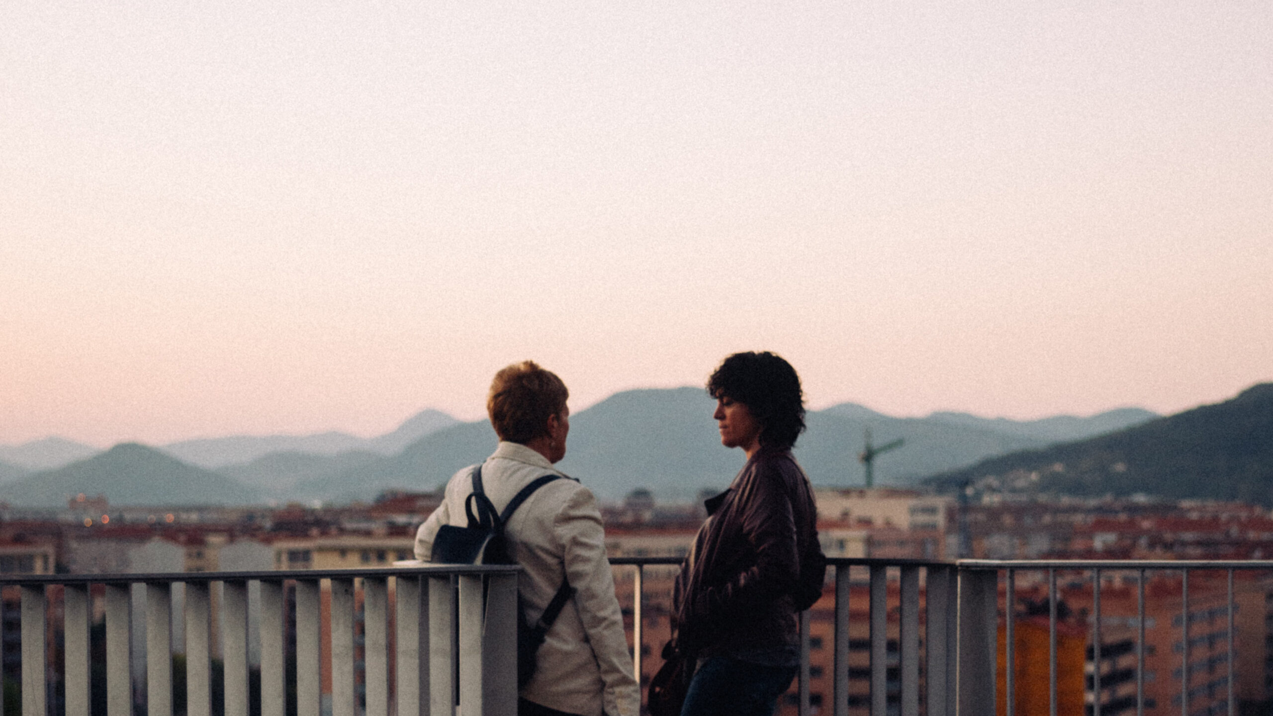 two people talking overlooking a wall and skyline