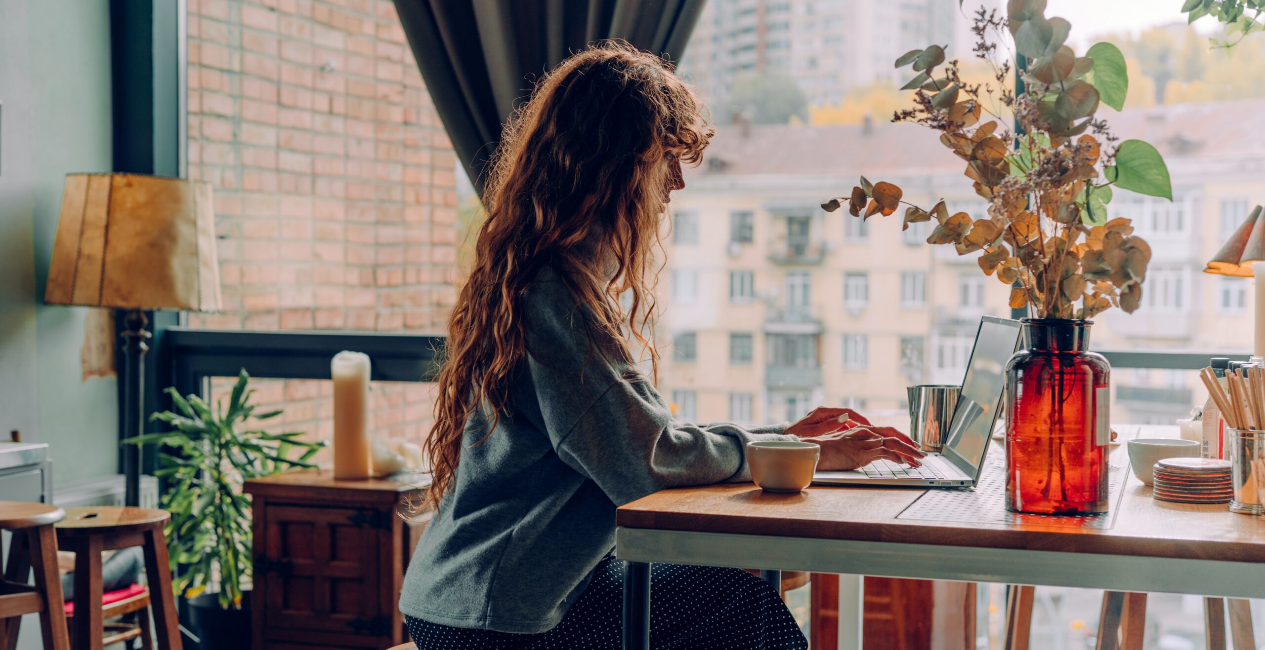 woman typing at coffee shop table