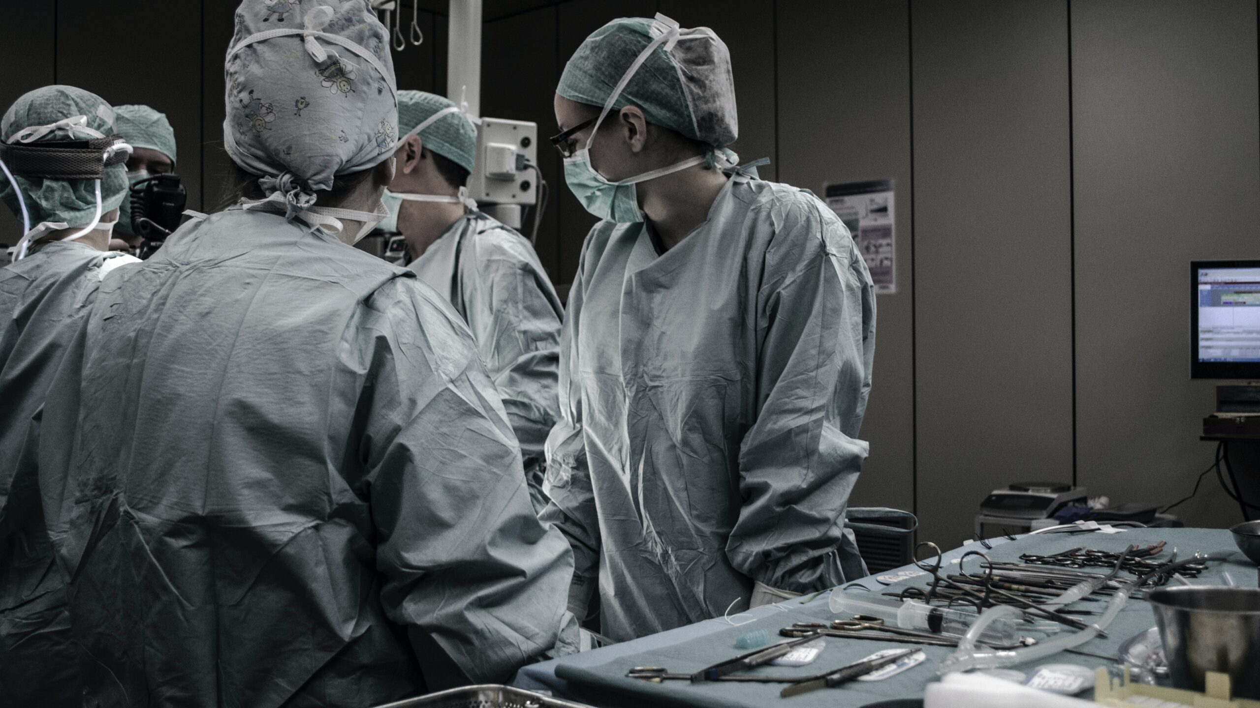 doctors and nurses standing looking at patient in operating room