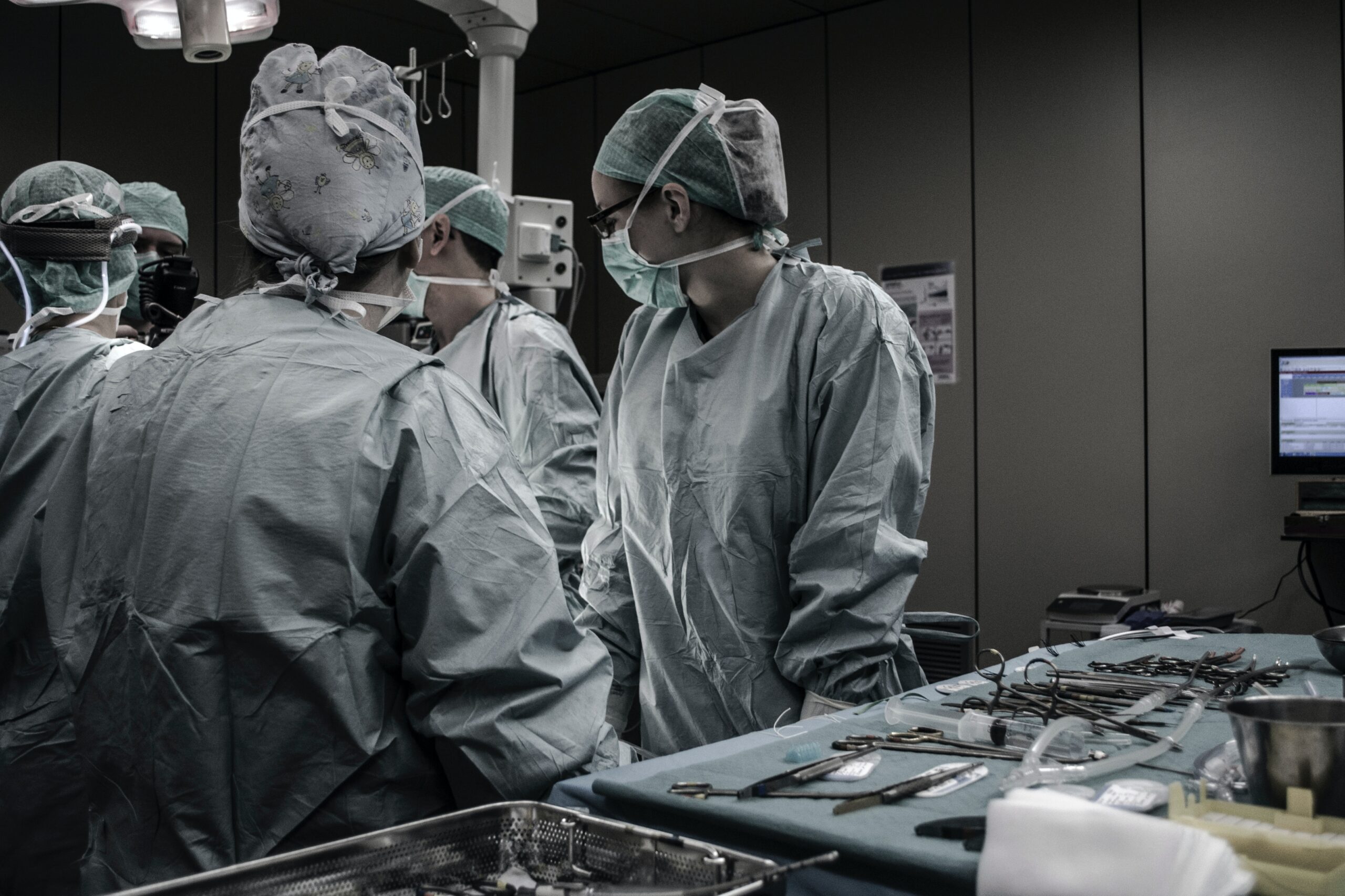 doctors and nurses standing looking at patient in operating room