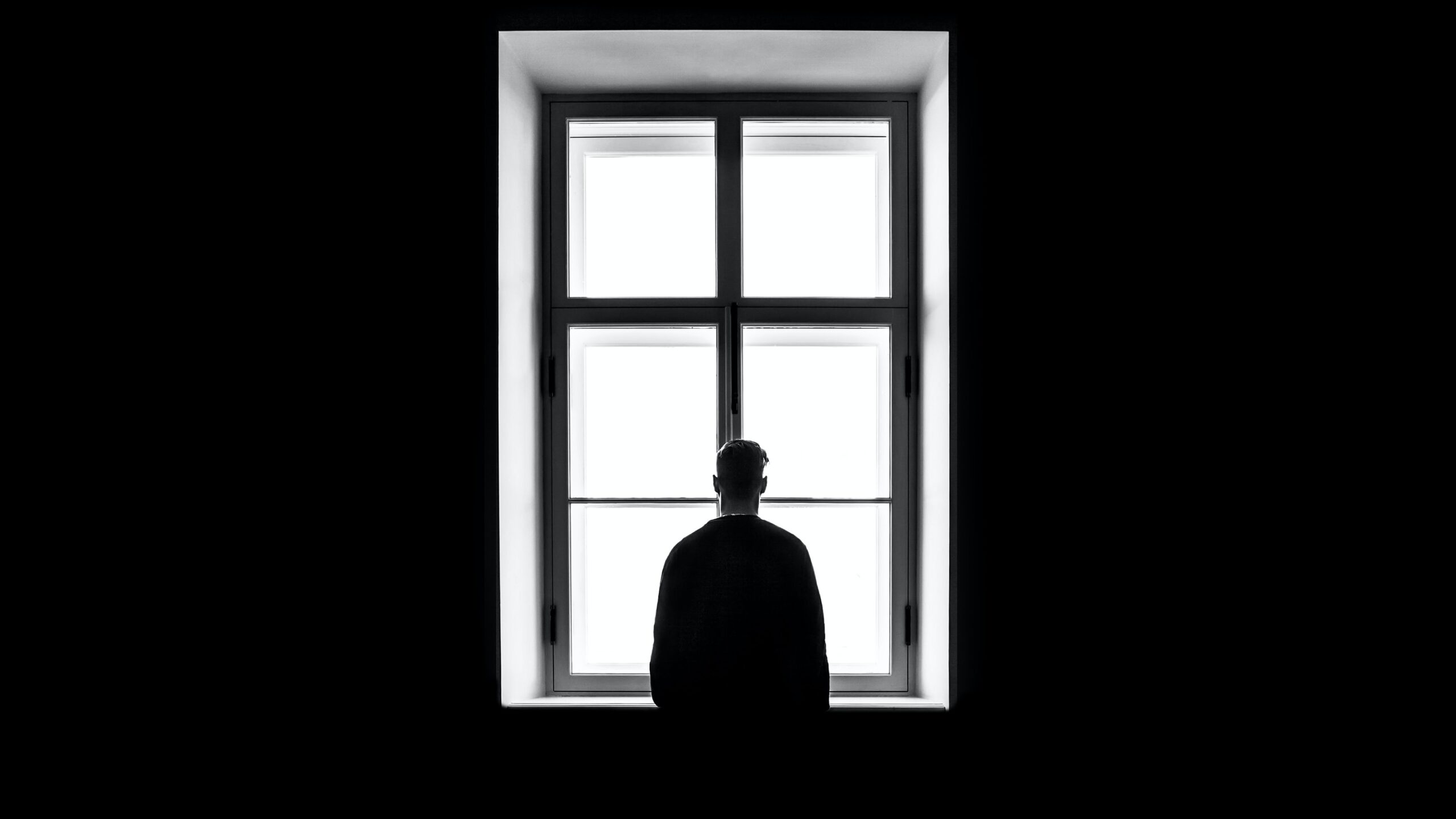 silhouette of man in window in black and white