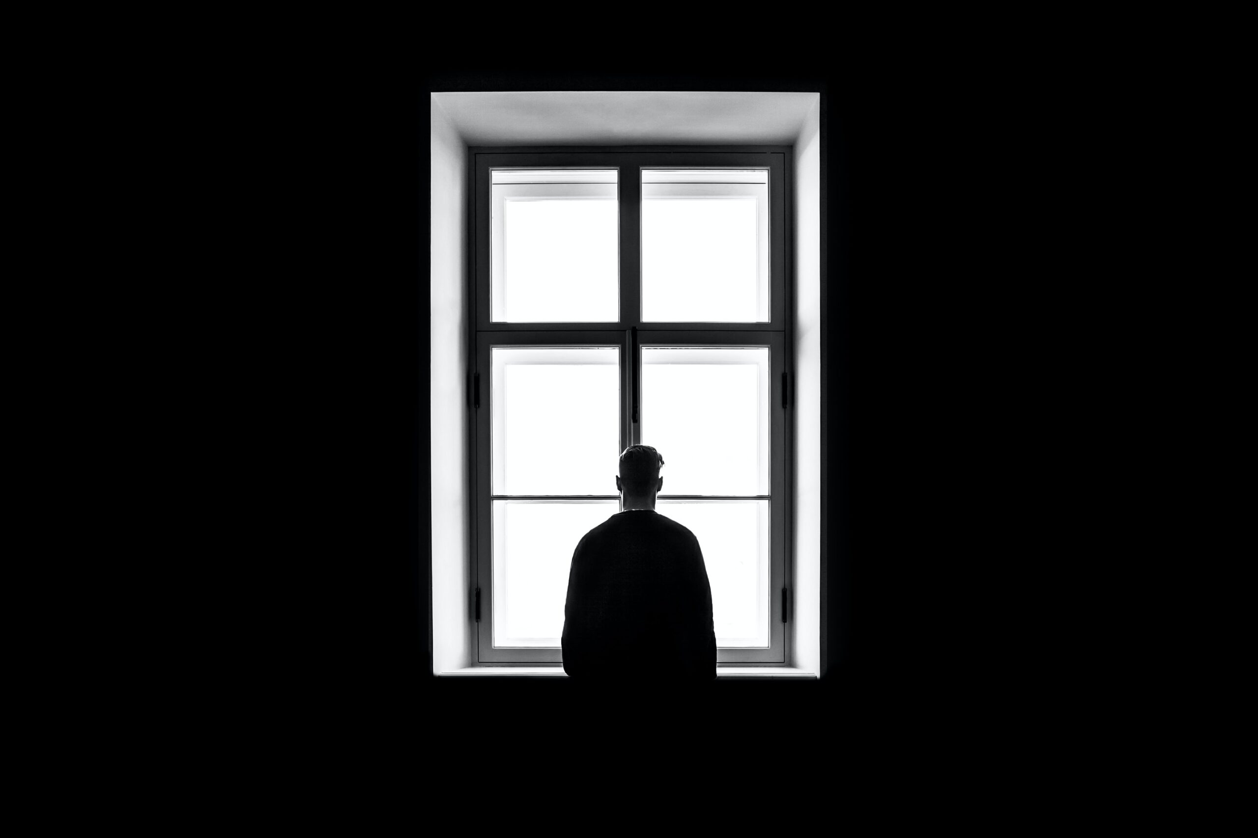 silhouette of man in window in black and white