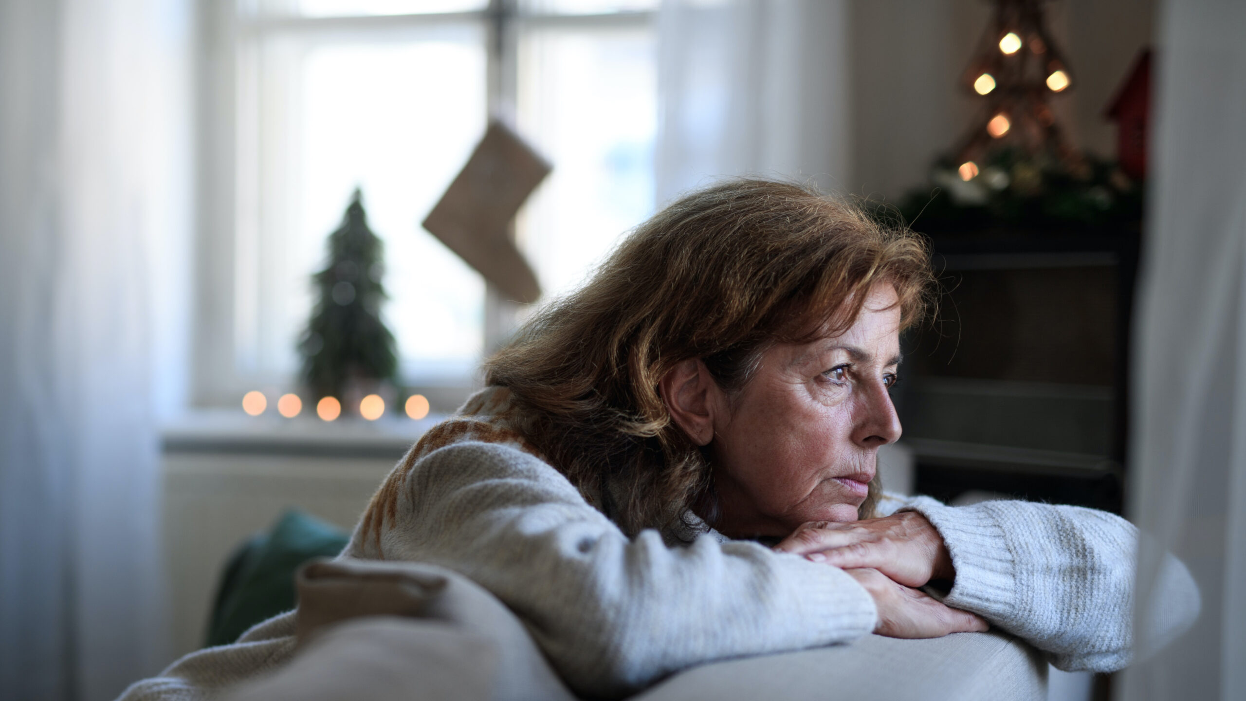 woman looks out window on holiday