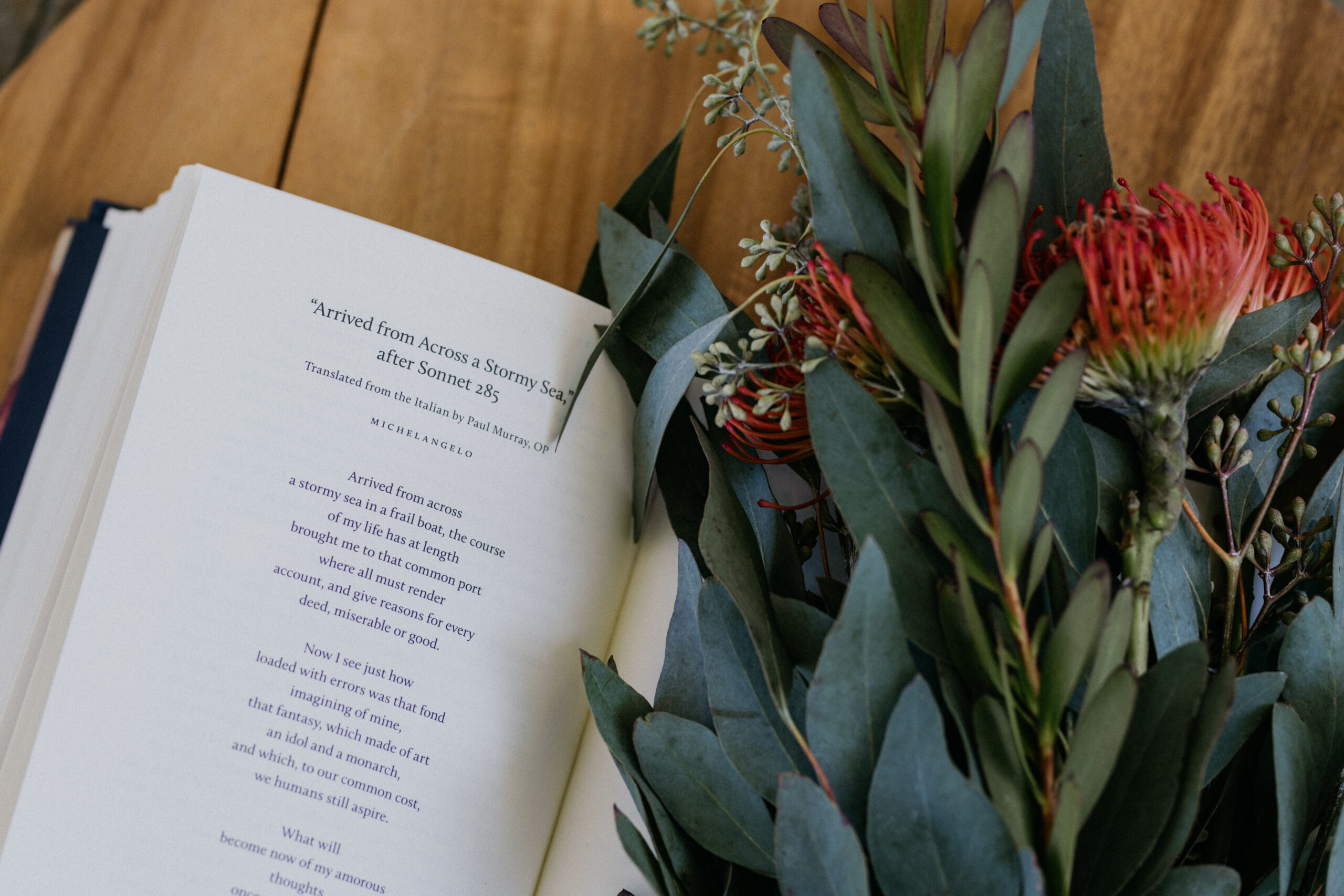 book of poetry open with flowers nearby