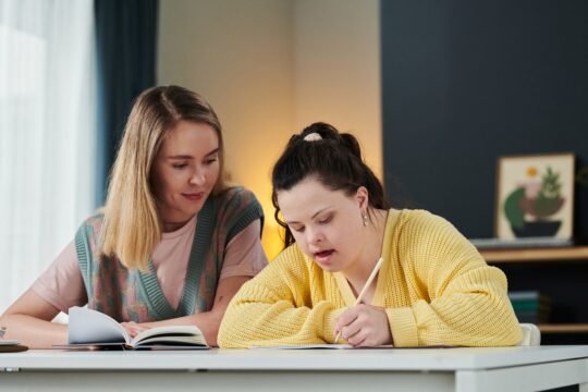 two women seated looking at books