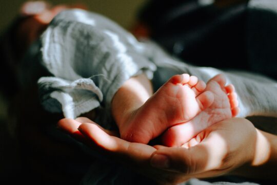 hands cradling a tiny baby's feet