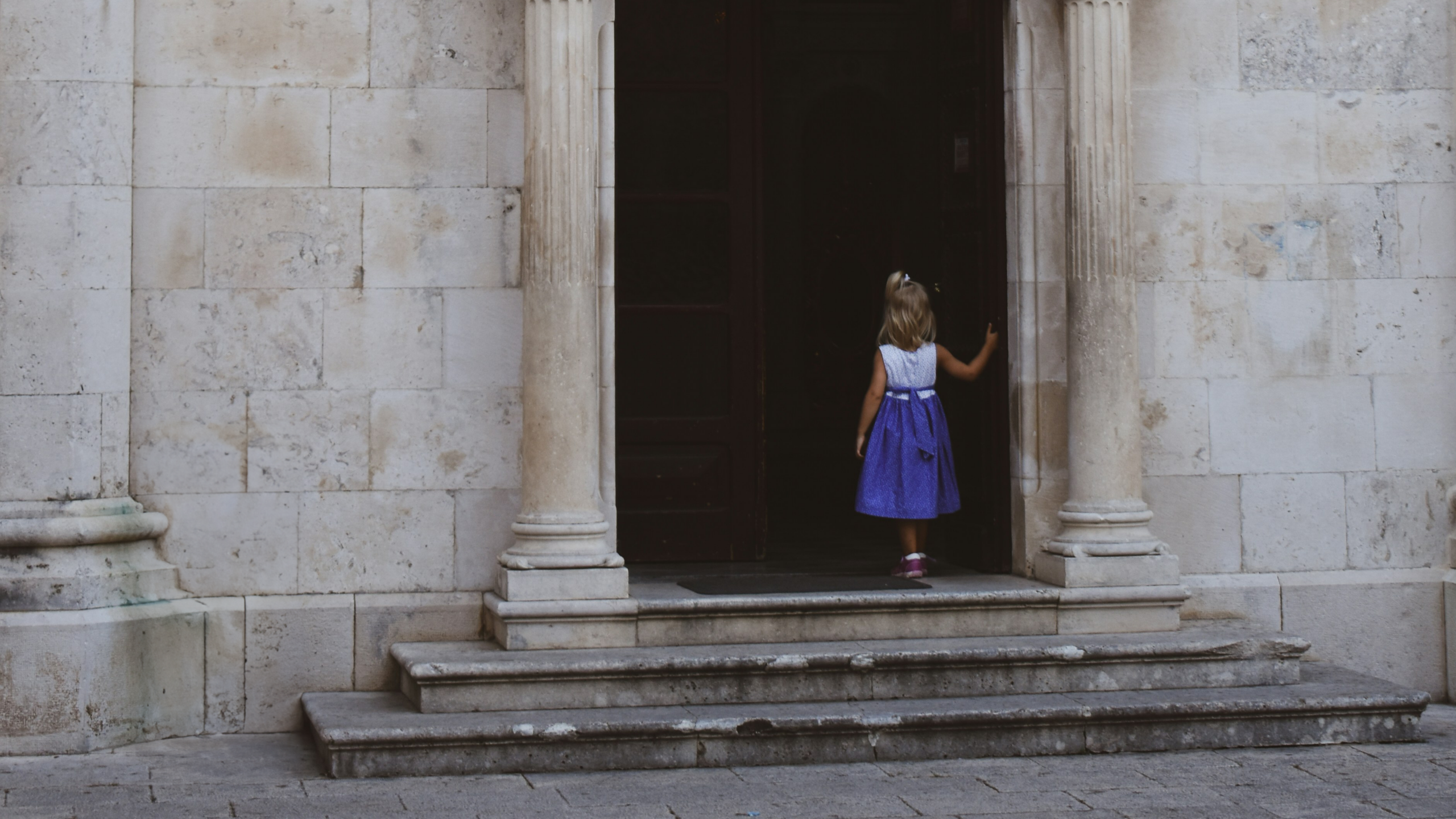 child standing at the doorway of a church
