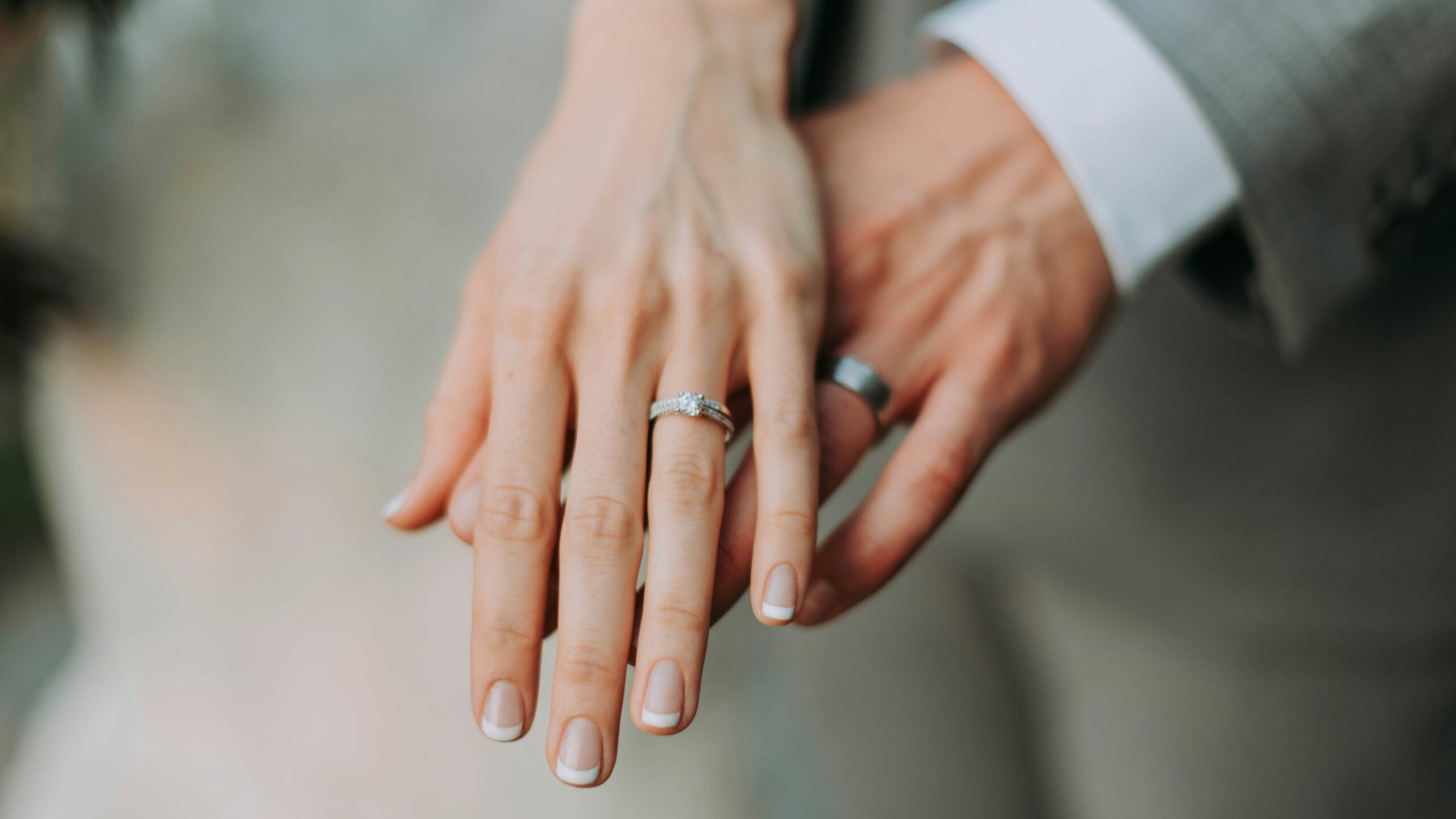 Man and wife holding out hands with their wedding bands