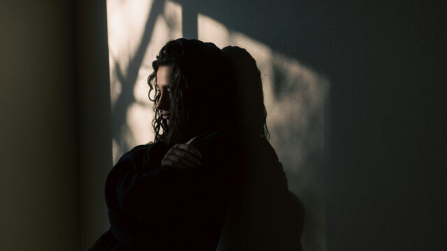 Girl looking sad and lonely in a shadowy room
