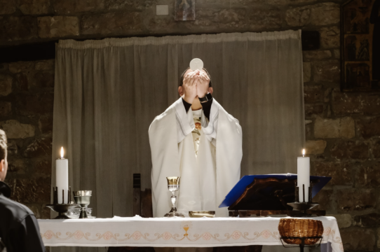 priest holding up the Eucharist