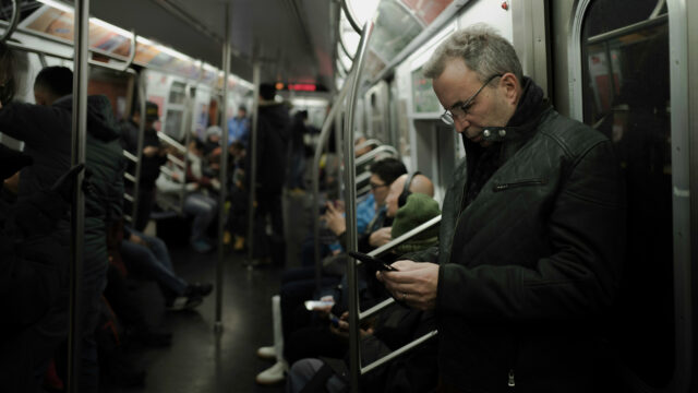 People reading on their phones while commuting