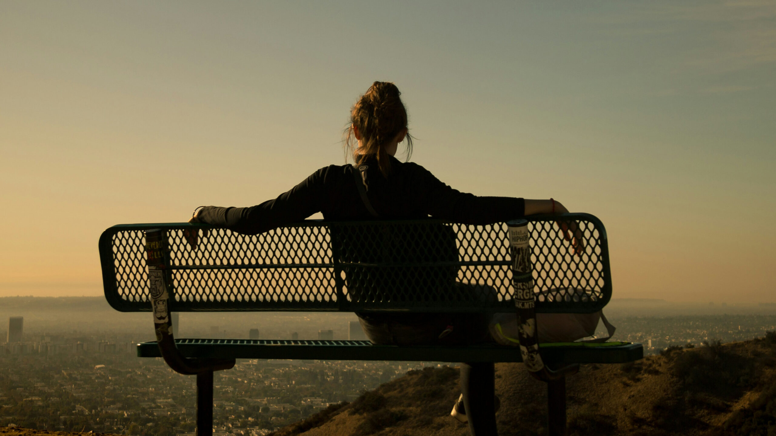 Silhouette of a woman sitting on a bench