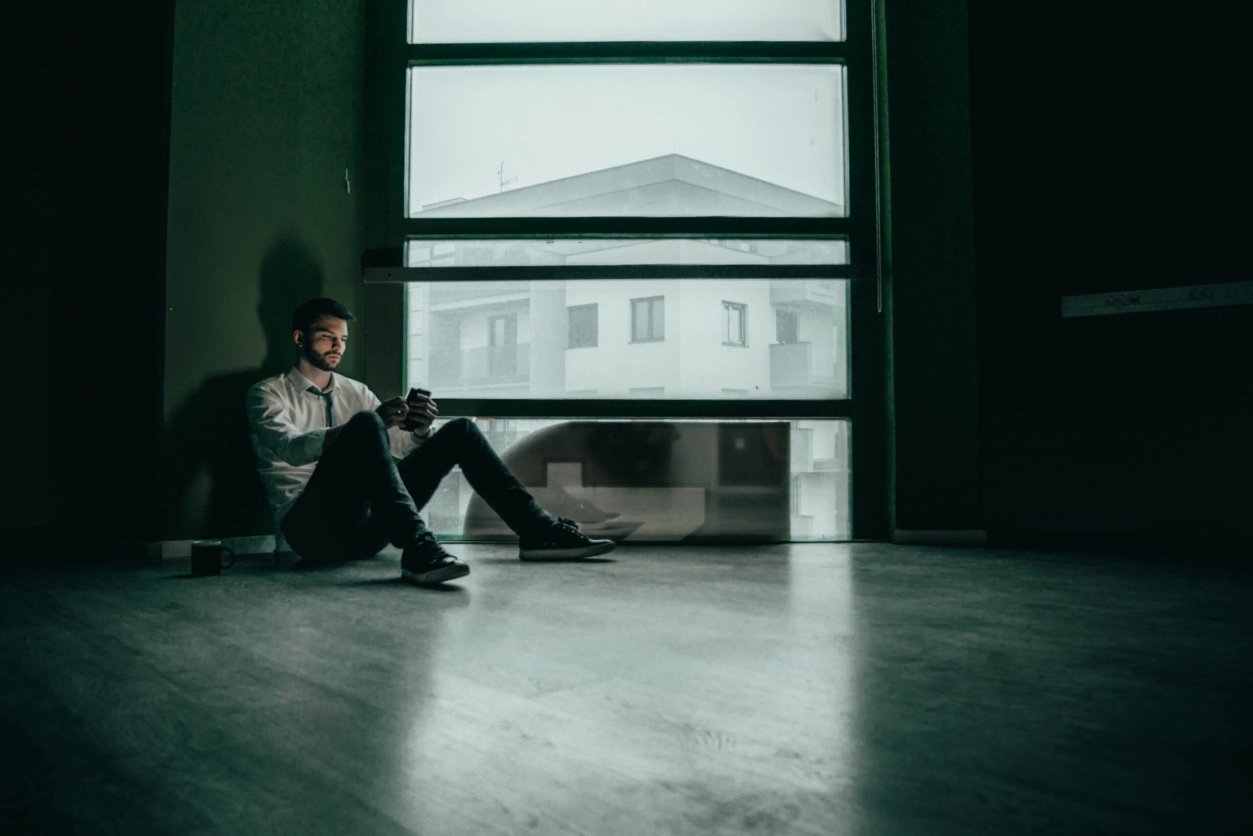 Man sitting alone looking at his phone