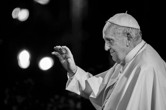 Pope Francis with his hand raised