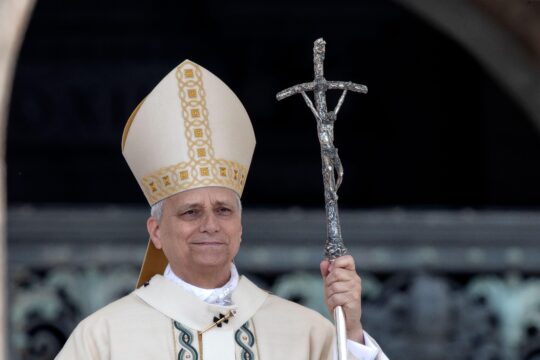 Pope Leo XIV standing with a cross