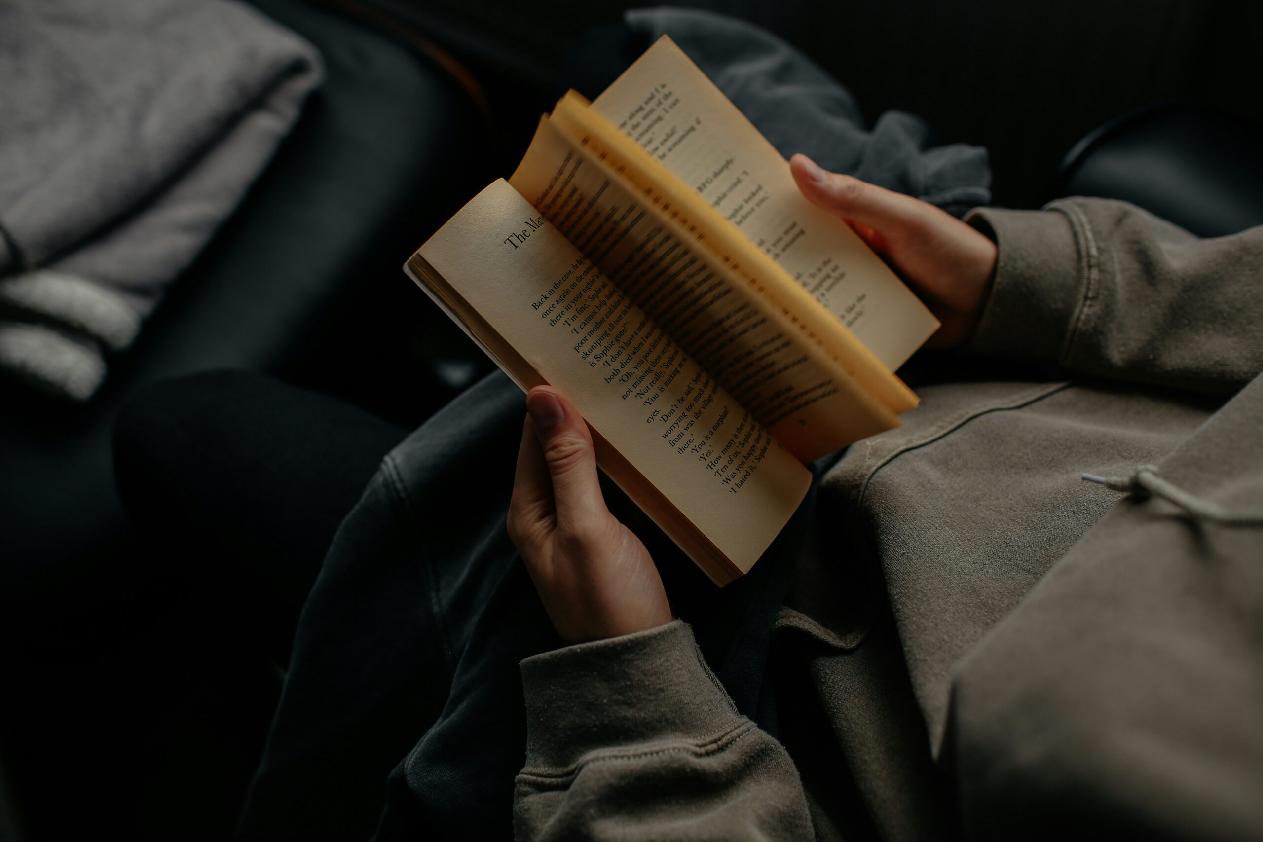 person looking at pages in an open book