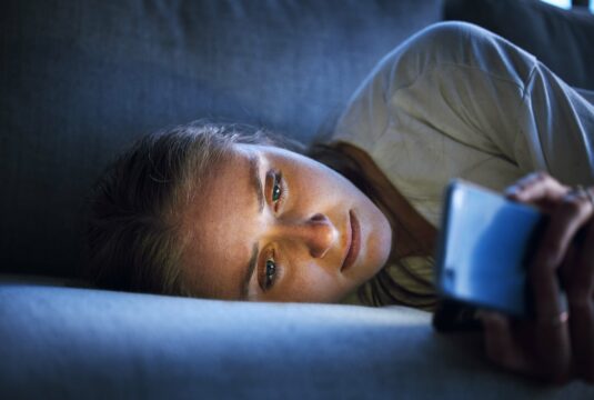 lady on her phone in bed scrolling
