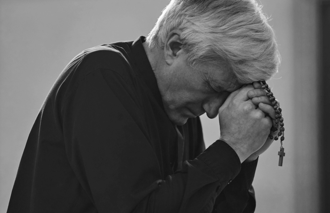 old man praying the rosary