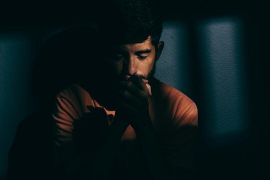 man in dark looking down