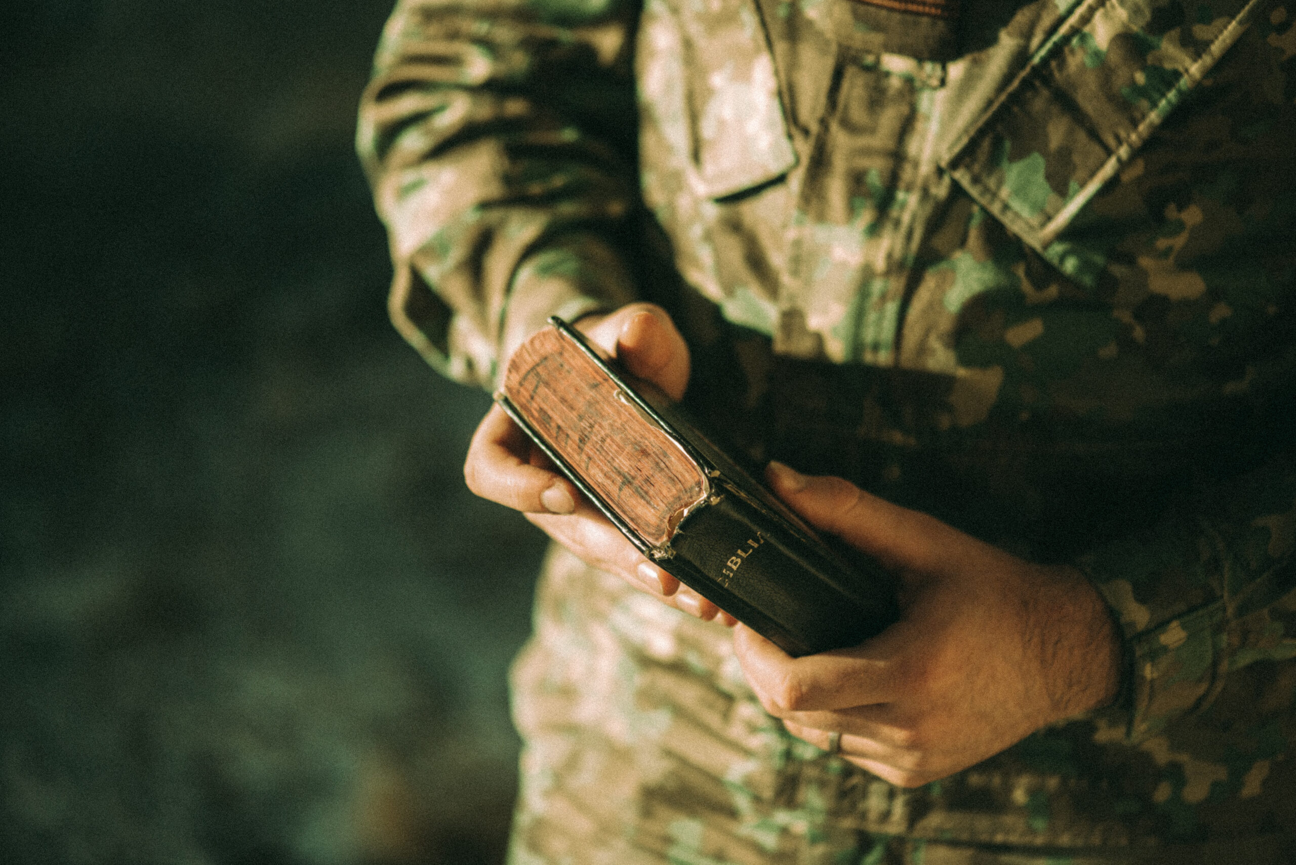 camo clad man holding bible