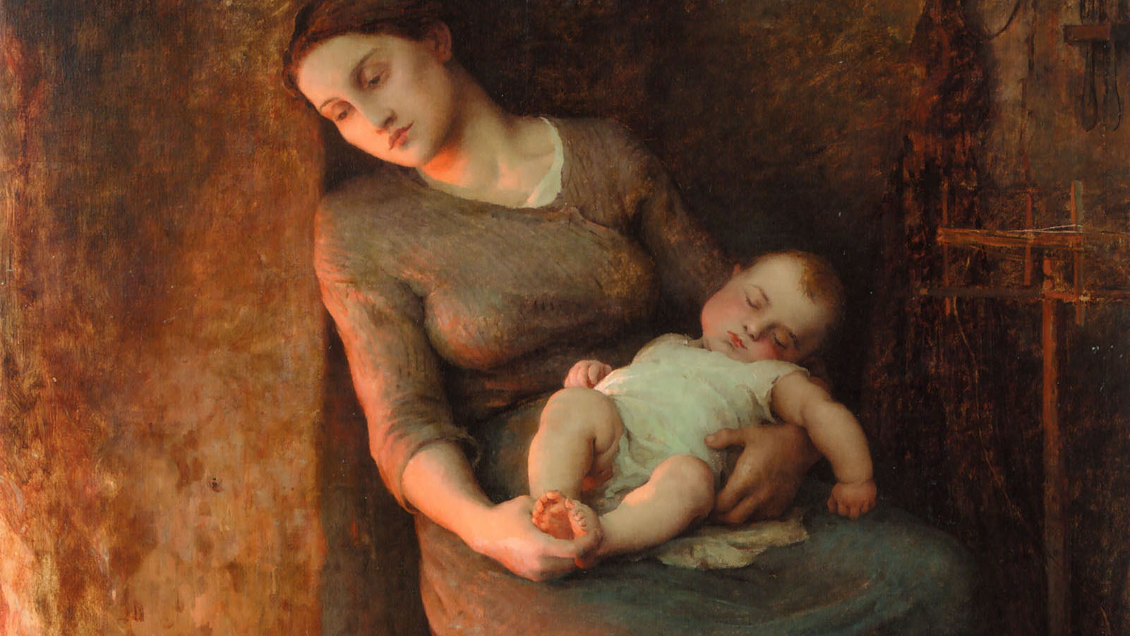 A tired woman holds her sleeping baby