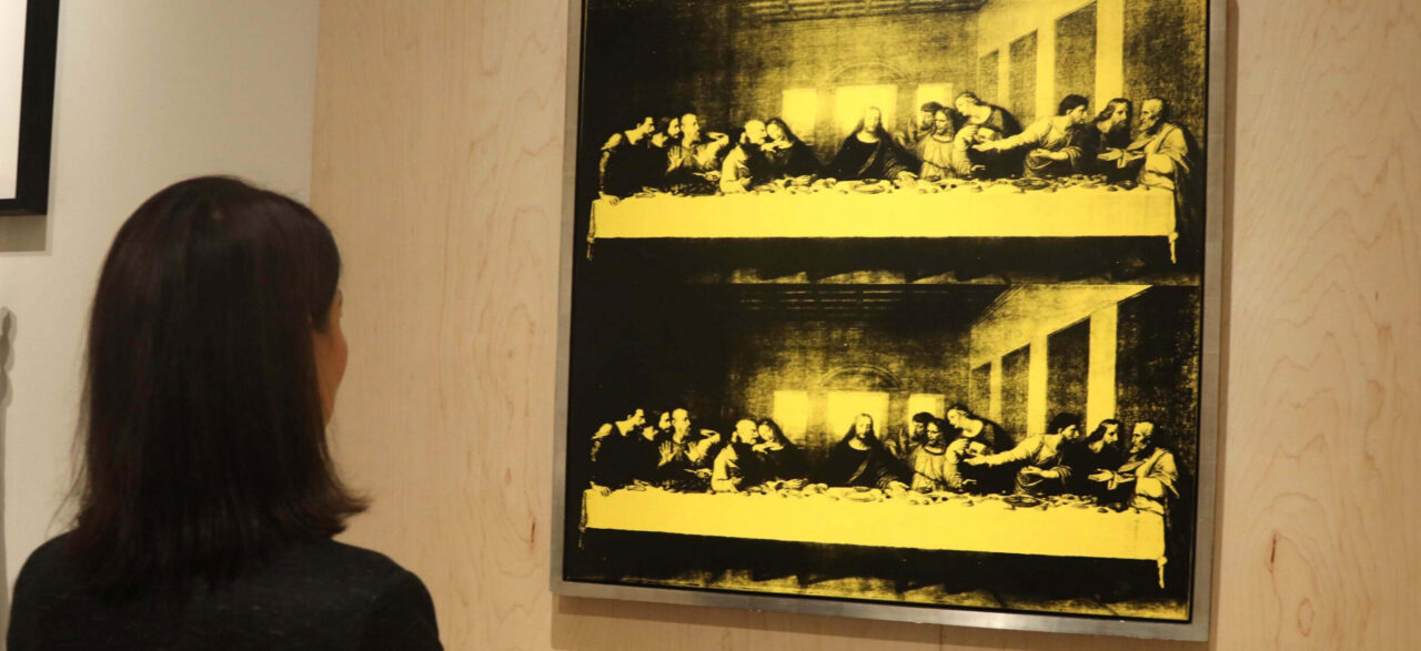 A woman views The Last Supper by artist Andy Warhol